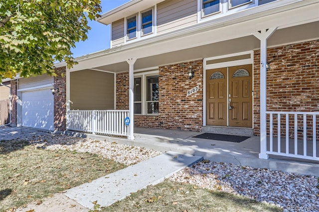 property entrance featuring a garage and covered porch