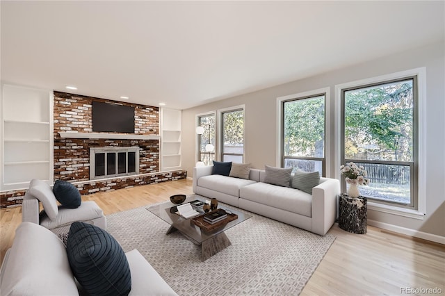 living room featuring a fireplace, wood-type flooring, and built in shelves