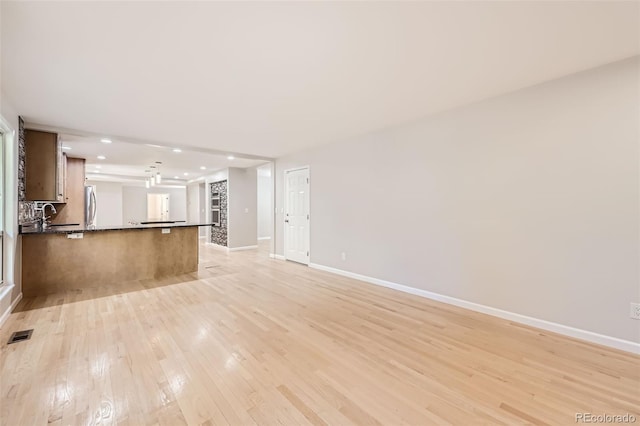 unfurnished living room with light wood-type flooring