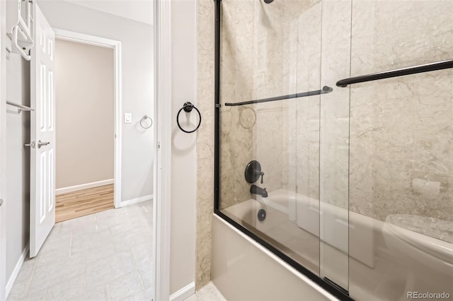 bathroom with wood-type flooring and combined bath / shower with glass door