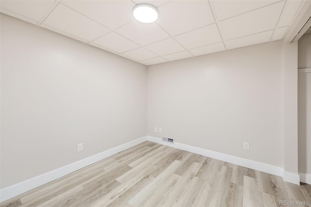 unfurnished room with a paneled ceiling and light hardwood / wood-style floors