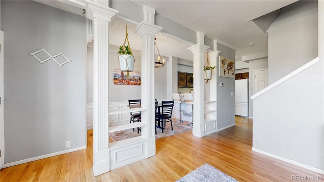 9758 Laredo St Unit 22D, Commerce City, CO 80022 - interior space featuring an inviting chandelier, baseboards, ornate columns, and wood finished floors