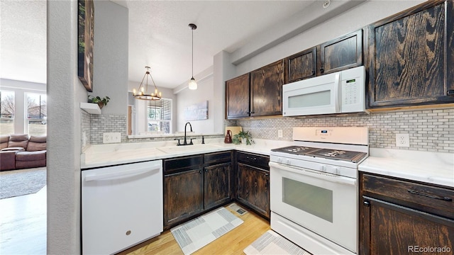 9758 Laredo St Unit 22D, Commerce City, CO 80022 - kitchen featuring a sink, dark brown cabinetry, white appliances, and a healthy amount of sunlight