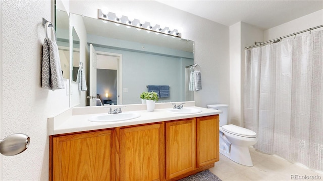 9758 Laredo St Unit 22D, Commerce City, CO 80022 - bathroom featuring double vanity, toilet, a shower with curtain, and a sink