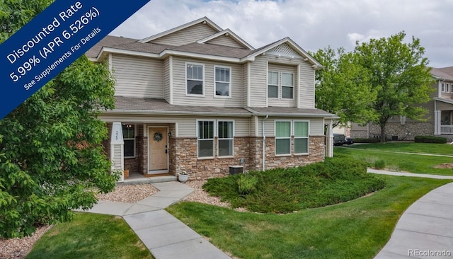 9758 Laredo St Unit 22D, Commerce City, CO 80022 - view of front facade with a front yard, stone siding, and roof with shingles