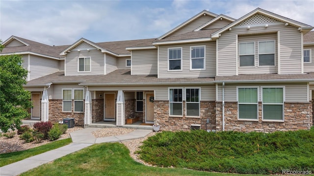 9758 Laredo St Unit 22D, Commerce City, CO 80022 - view of front of home featuring stone siding and roof with shingles