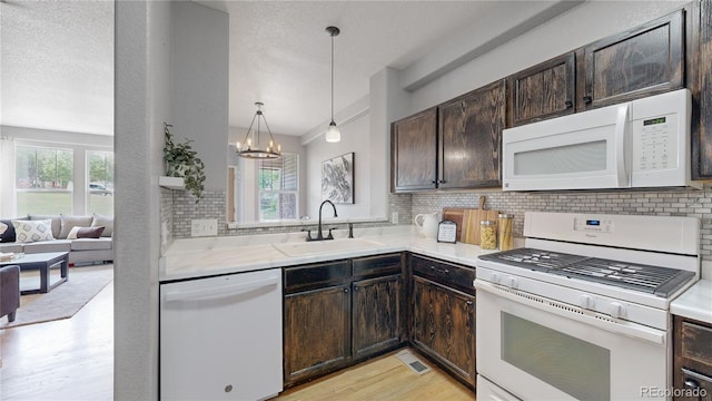 9758 Laredo St Unit 22D, Commerce City, CO 80022 - kitchen with white appliances, dark brown cabinets, decorative backsplash, and light countertops
