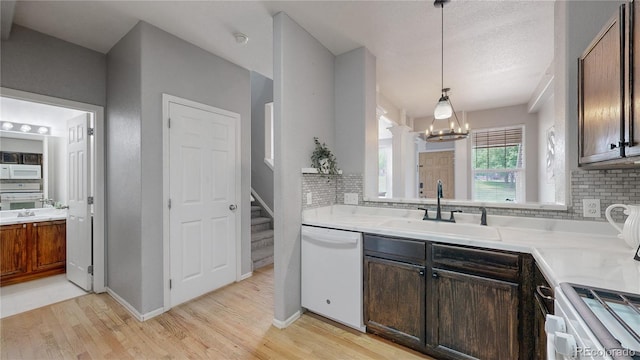 9758 Laredo St Unit 22D, Commerce City, CO 80022 - kitchen featuring white appliances, decorative backsplash, a chandelier, and light wood finished floors
