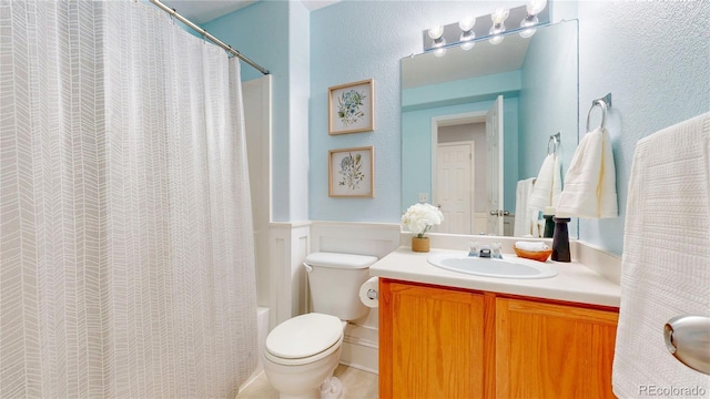9758 Laredo St Unit 22D, Commerce City, CO 80022 - bathroom featuring vanity, wainscoting, and shower / tub combo with curtain