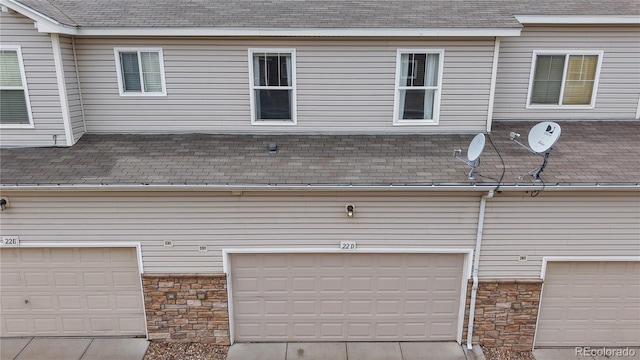 9758 Laredo St Unit 22D, Commerce City, CO 80022 - exterior view of gutters, roof with shingles, stone siding, and a downspout