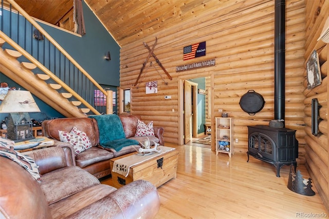 living room featuring wood-type flooring, high vaulted ceiling, wooden ceiling, and a wood stove