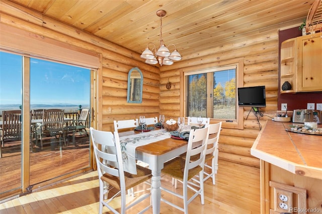 dining area with an inviting chandelier, wooden ceiling, log walls, and light wood-type flooring