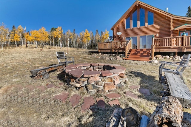 rear view of property featuring a wooden deck and an outdoor fire pit