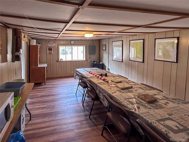 recreation room featuring beamed ceiling, coffered ceiling, wooden walls, and dark wood-type flooring