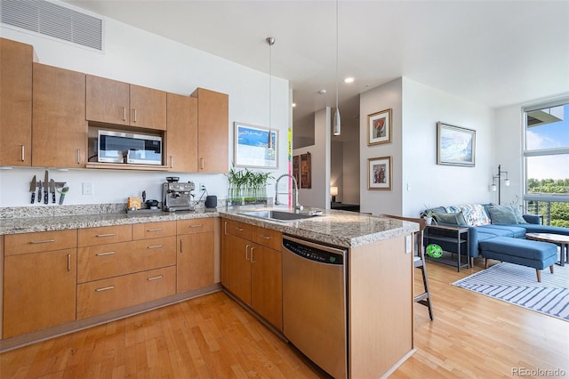 2958 Syracuse St Unit 403, Denver, CO 80238 - kitchen with appliances with stainless steel finishes, a sink, light wood-type flooring, open floor plan, and a peninsula
