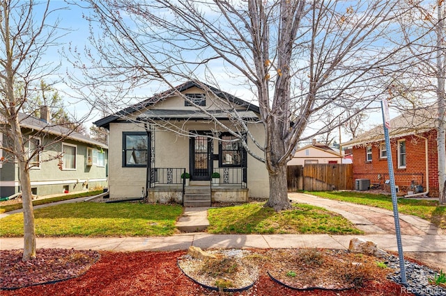 2676 S Lincoln St, Denver, CO 80210 - view of front facade with a porch, fence, cooling unit, a front lawn, and stucco siding