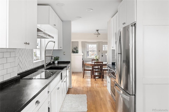 2676 S Lincoln St, Denver, CO 80210 - kitchen with dark countertops, tasteful backsplash, stainless steel appliances, and under cabinet range hood