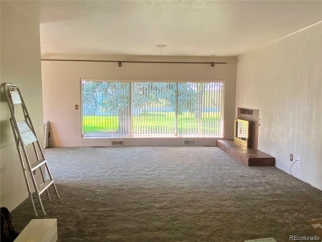 unfurnished living room featuring carpet and a wealth of natural light