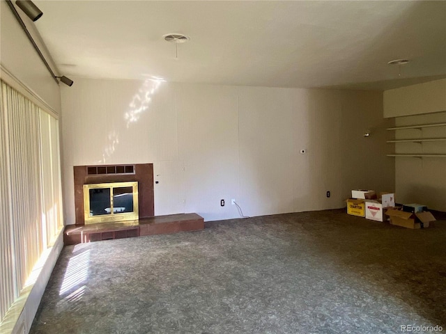 unfurnished living room with a tiled fireplace