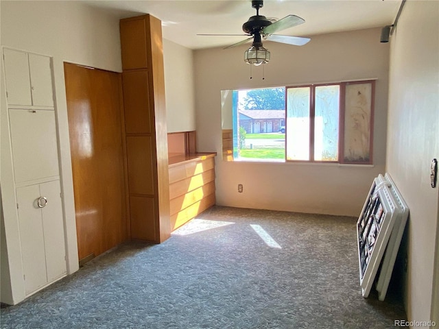 unfurnished bedroom with ceiling fan, carpet floors, and heating unit