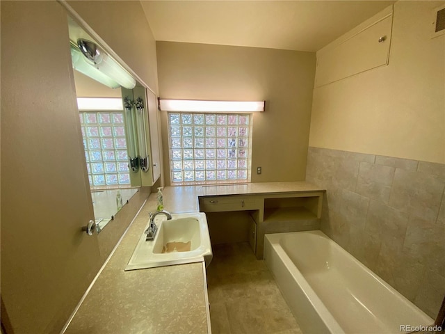 bathroom with a bathing tub, vanity, and plenty of natural light