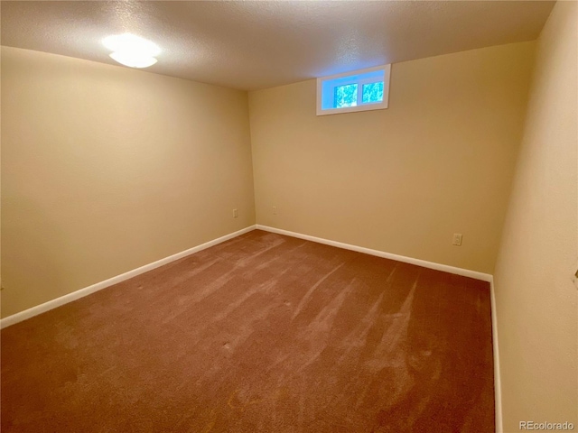 spare room with a textured ceiling and carpet