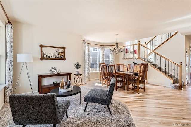 interior space with light wood-style flooring, baseboards, an inviting chandelier, and stairs