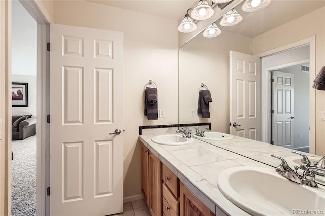 bathroom with tile patterned flooring, a sink, and double vanity