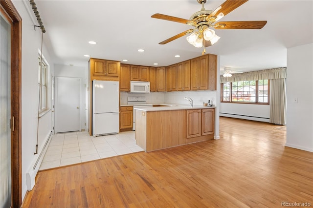 1840 E 84th Ave, Denver, CO 80229 - kitchen featuring white appliances, baseboard heating, a peninsula, light countertops, and a baseboard heating unit
