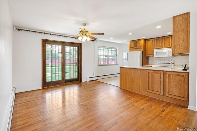 1840 E 84th Ave, Denver, CO 80229 - kitchen with white appliances, baseboard heating, a peninsula, light wood-style flooring, and ceiling fan