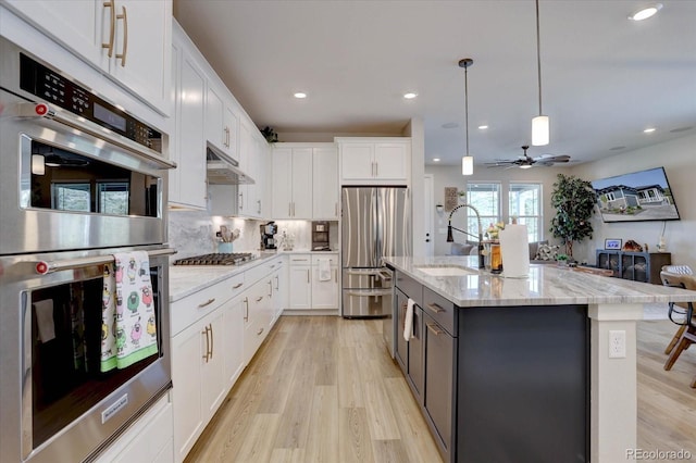 527 Felicity Loop, Castle Rock, CO 80109 - kitchen with appliances with stainless steel finishes, a sink, white cabinetry, open floor plan, and recessed lighting
