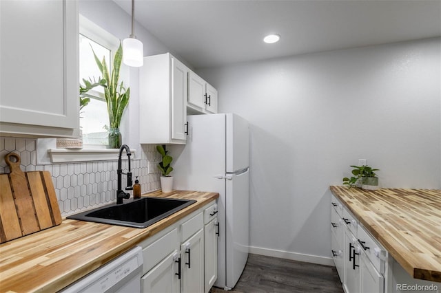 2829 W 53rd Ave Unit 104, Denver, CO 80221 - kitchen featuring wood counters, white dishwasher, tasteful backsplash, dark wood-style floors, and white cabinets
