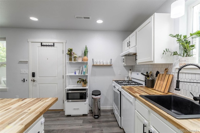 2829 W 53rd Ave Unit 104, Denver, CO 80221 - kitchen with white appliances, butcher block counters, dark wood-style floors, white cabinets, and decorative backsplash
