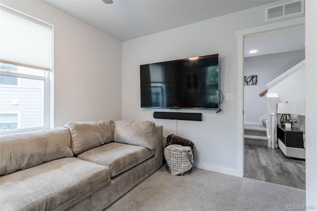 2829 W 53rd Ave Unit 104, Denver, CO 80221 - carpeted living area with stairs, wood finished floors, and a ceiling fan