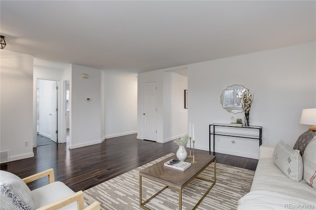 living area with visible vents, baseboards, and wood finished floors