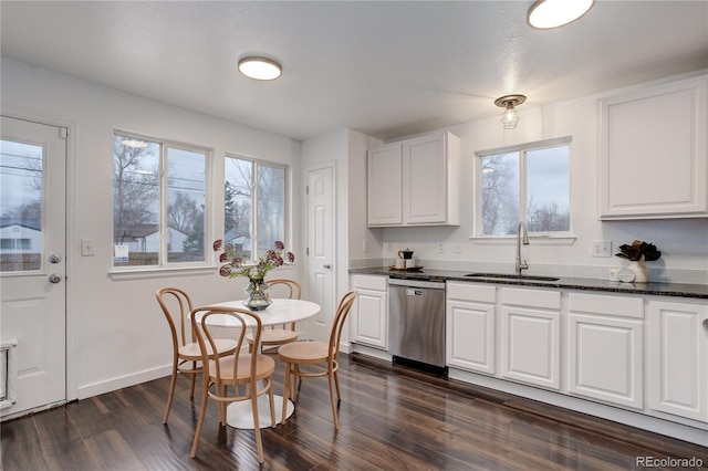 kitchen featuring stainless steel dishwasher, dark wood-type flooring, white cabinets, and a sink