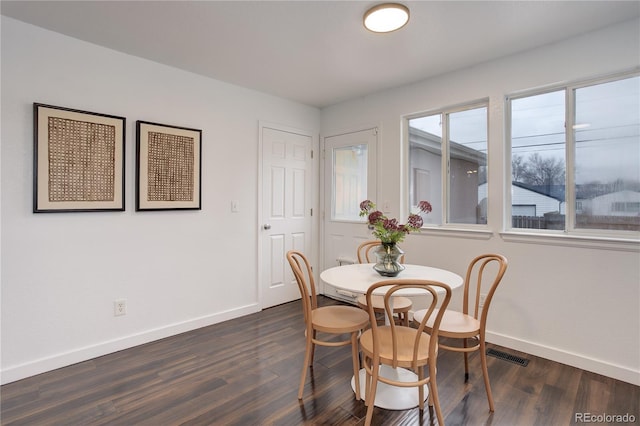 dining room with visible vents, baseboards, and dark wood finished floors