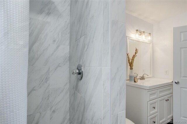 bathroom featuring vanity and tiled shower