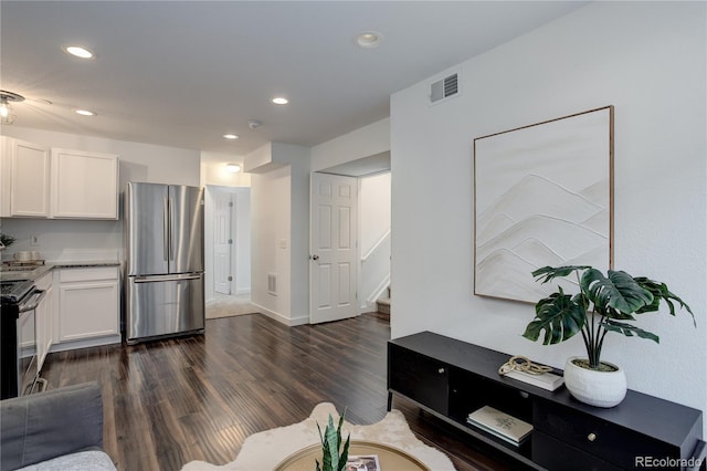 living area featuring stairway, visible vents, baseboards, recessed lighting, and dark wood-style flooring