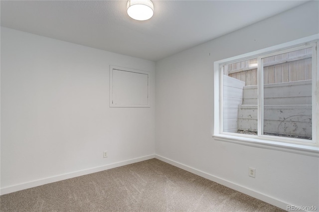 unfurnished room with baseboards and carpet flooring