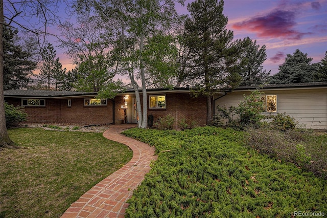 ranch-style home with brick siding and a front yard