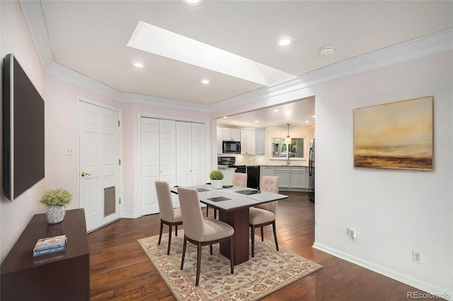 dining space with a skylight, baseboards, dark wood-style floors, ornamental molding, and recessed lighting