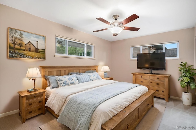 bedroom featuring baseboards, light carpet, and ceiling fan