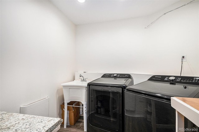 clothes washing area with laundry area, a sink, recessed lighting, wood finished floors, and washing machine and dryer