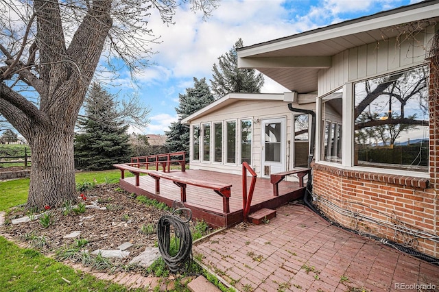 exterior space with brick siding and a deck