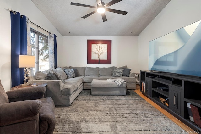 living room featuring ceiling fan, vaulted ceiling, hardwood / wood-style floors, and a textured ceiling