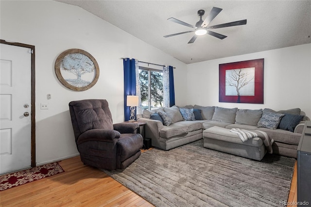 living room with lofted ceiling, hardwood / wood-style flooring, and ceiling fan