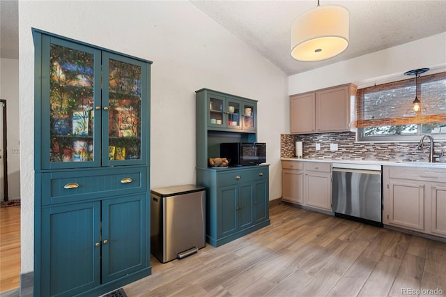 kitchen with stainless steel appliances, hanging light fixtures, sink, and light hardwood / wood-style flooring