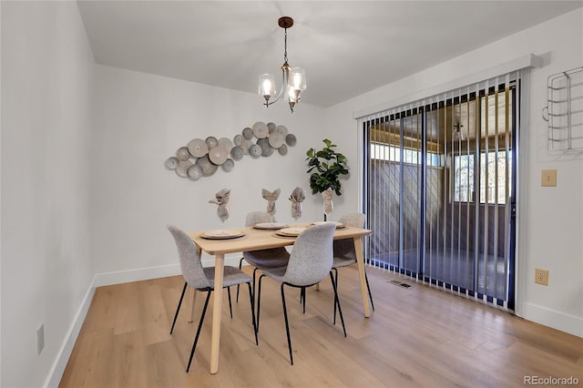 dining area featuring hardwood / wood-style flooring and a notable chandelier