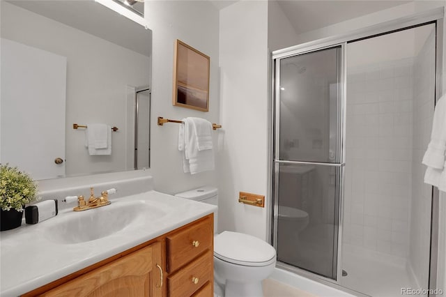 bathroom with vanity, a shower with shower door, and toilet